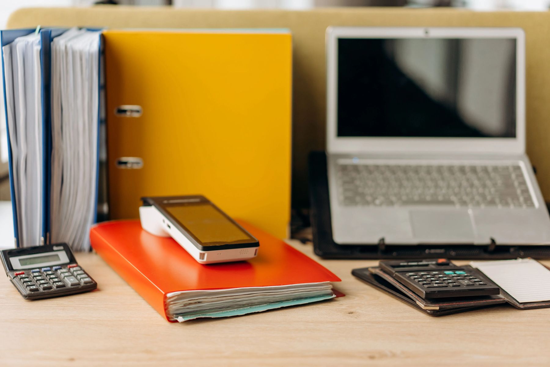 Mesa de trabalho com documentos e notebook, rotina da equipe Penna Gestão